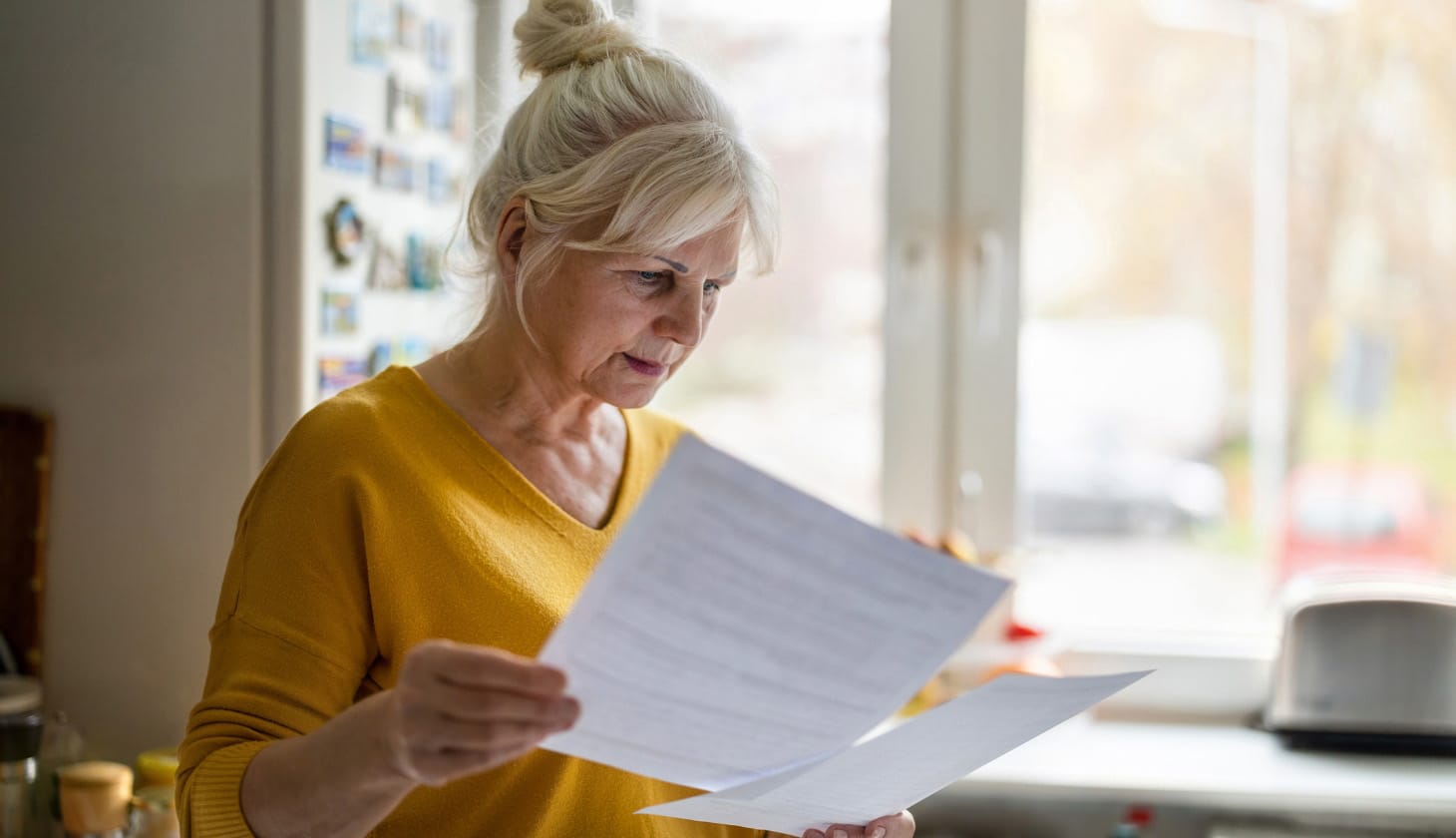 Woman reviewing paperwork in her kitchen